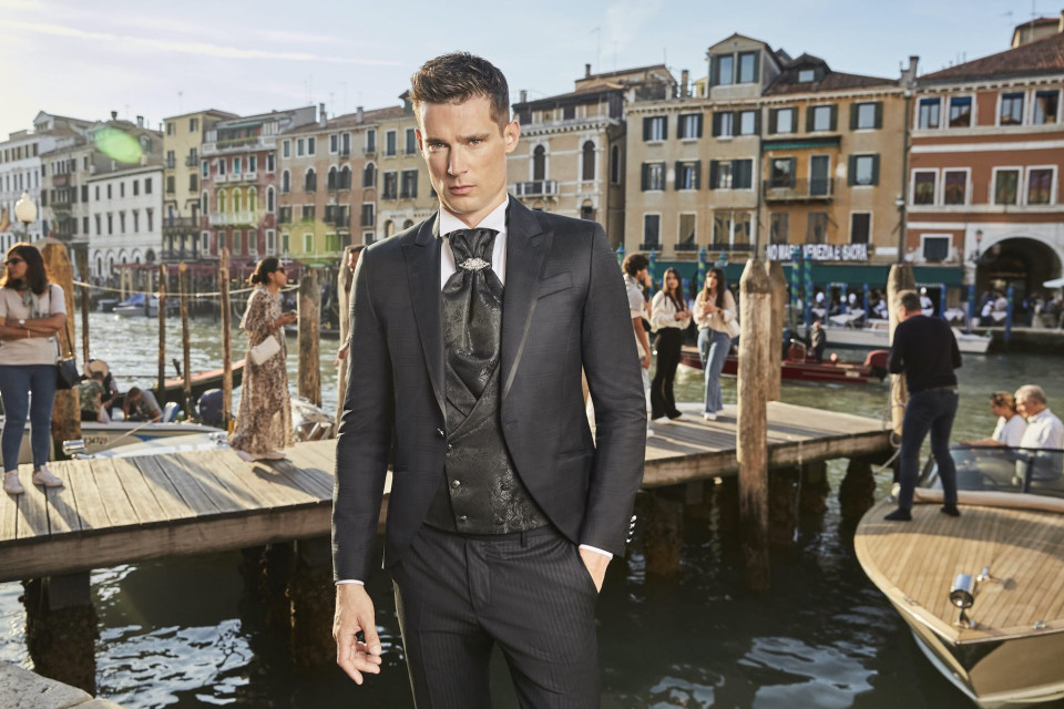 een man in een pak en stropdas staat op een dok