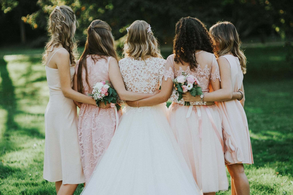 bruidsmeisjes in roze jurken die samen staan