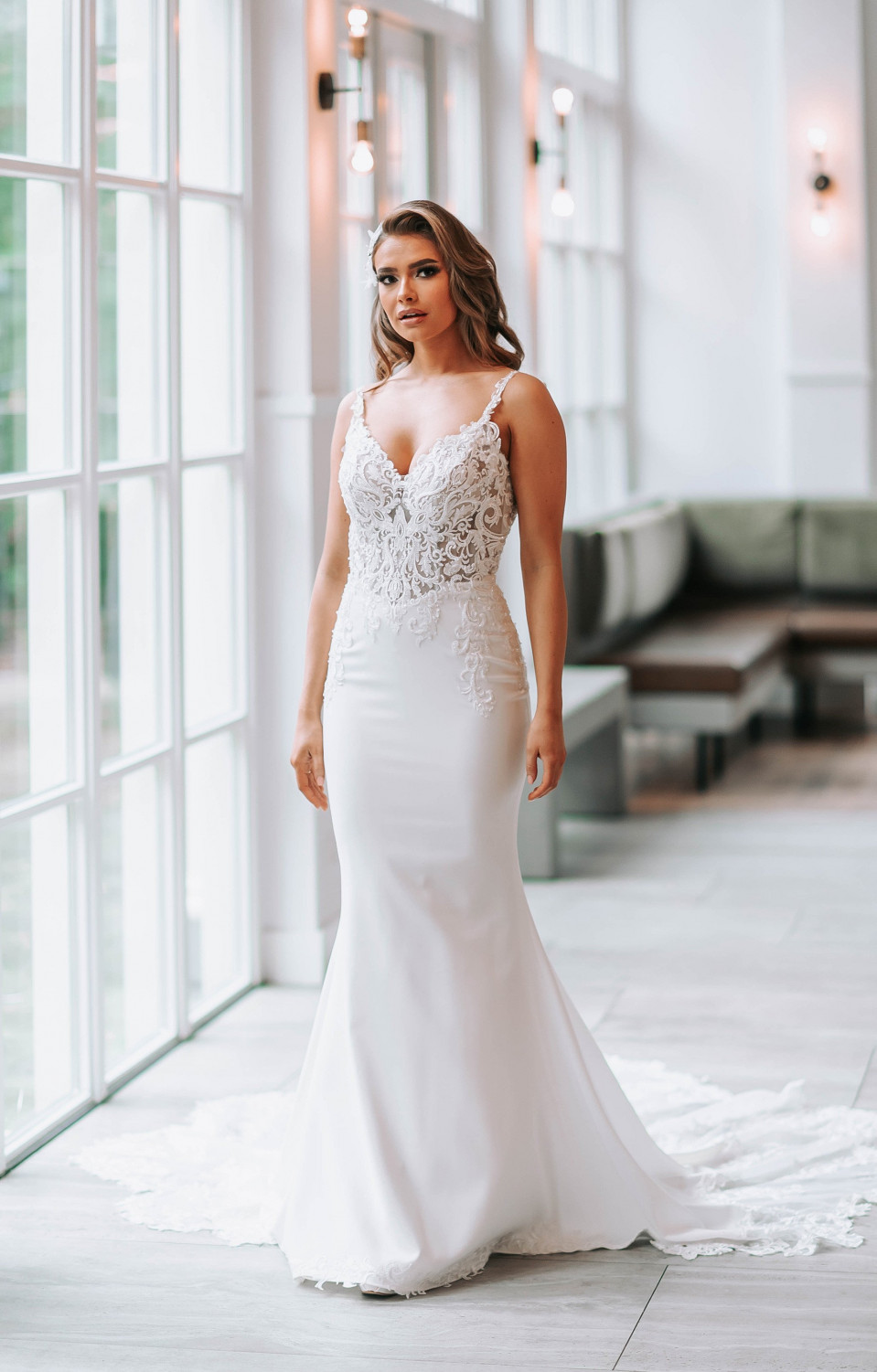 een bruid in een witte trouwjurk die staat in een grote kamer