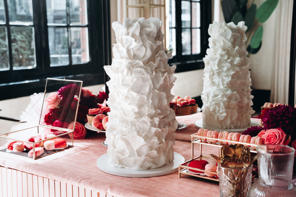 een tafel met een taart erop en een roze tafelkleed