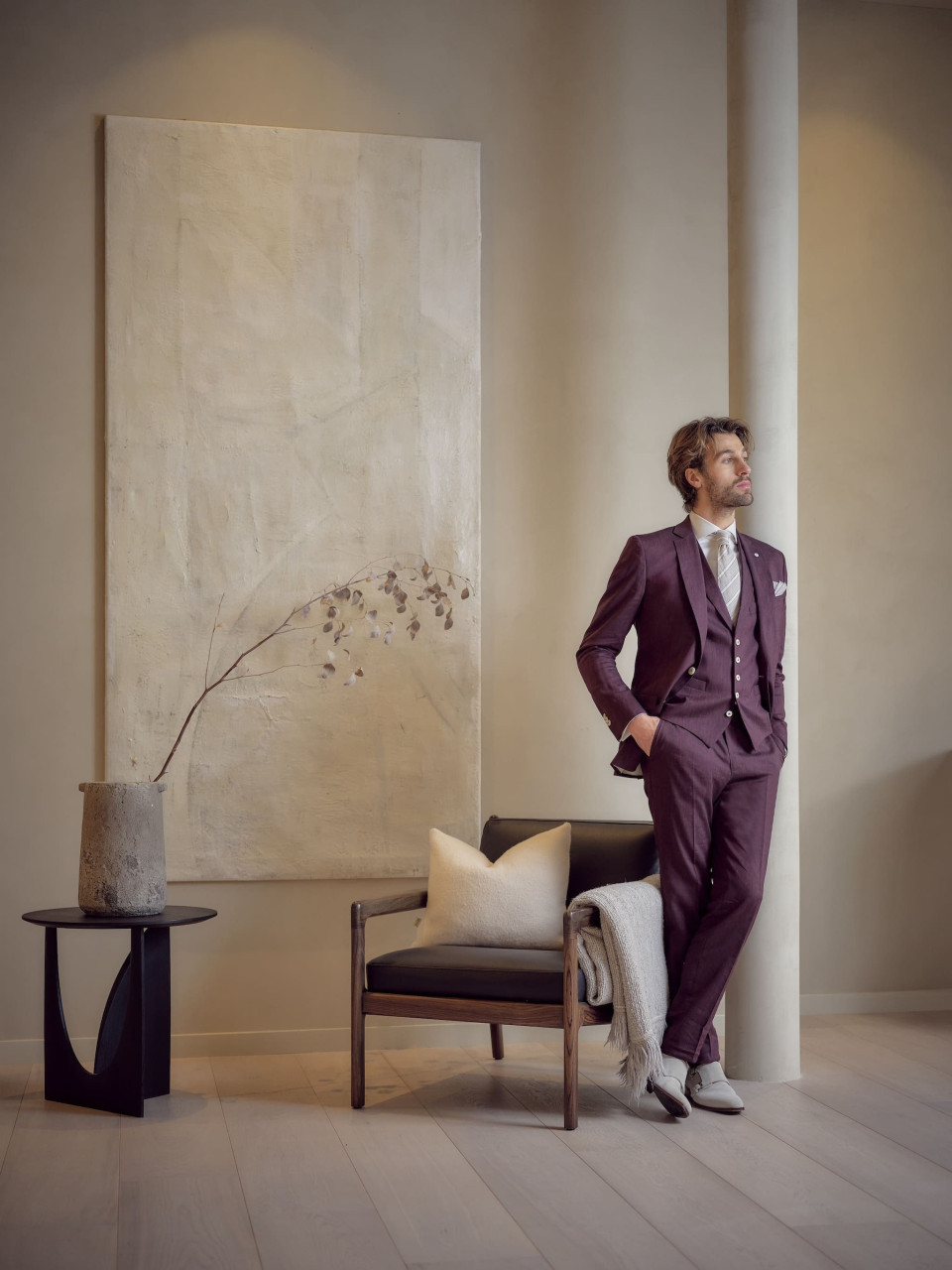 een man in een paars pak die in een kamer staat