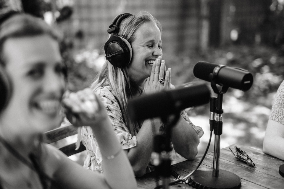 drie vrouwen met koptelefoon die aan een tafel zitten