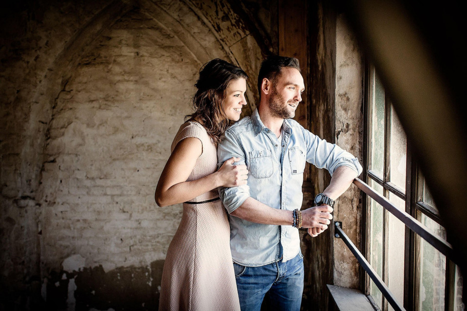 een verloofd stel staat in een oud gebouw