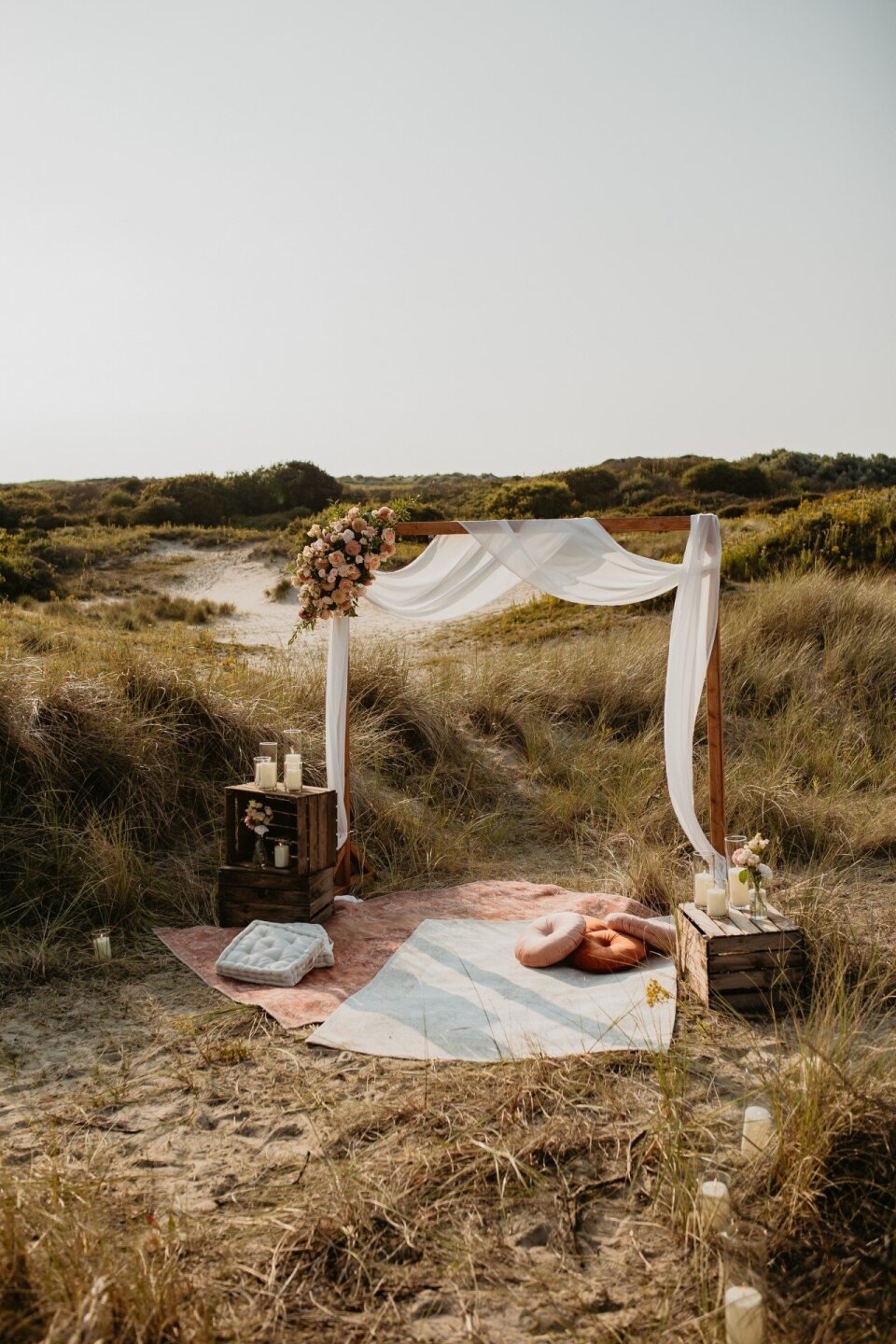Strandbruiloft picknickstyling met ceremonieboog