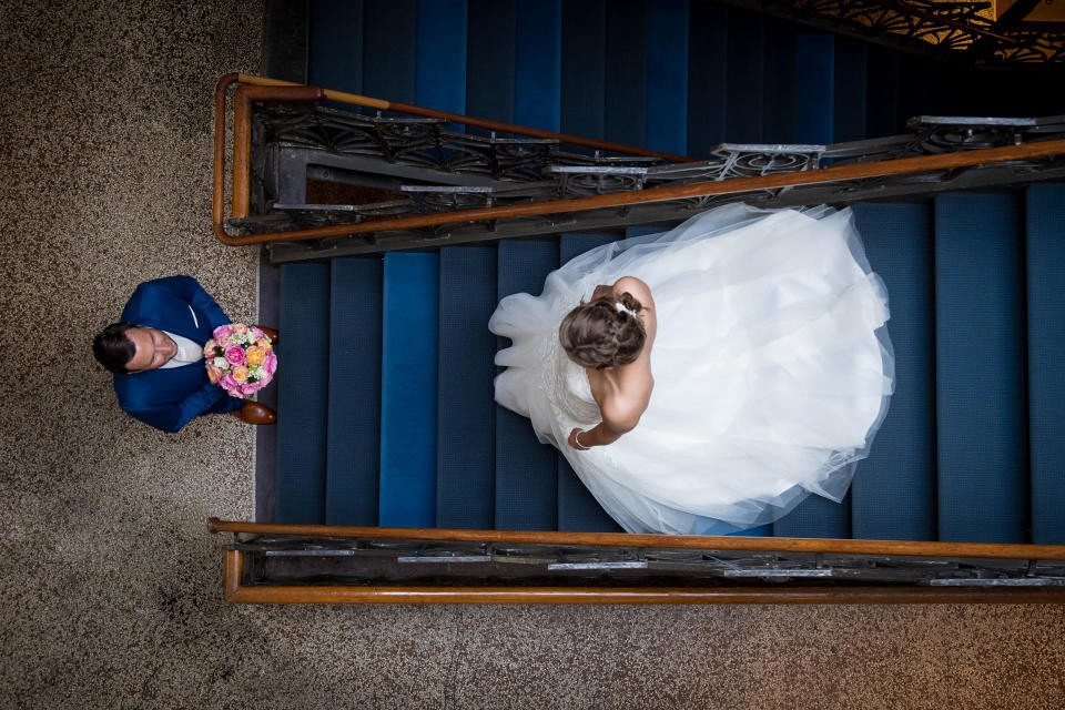 een bruid en bruidegom op de trap van een gebouw