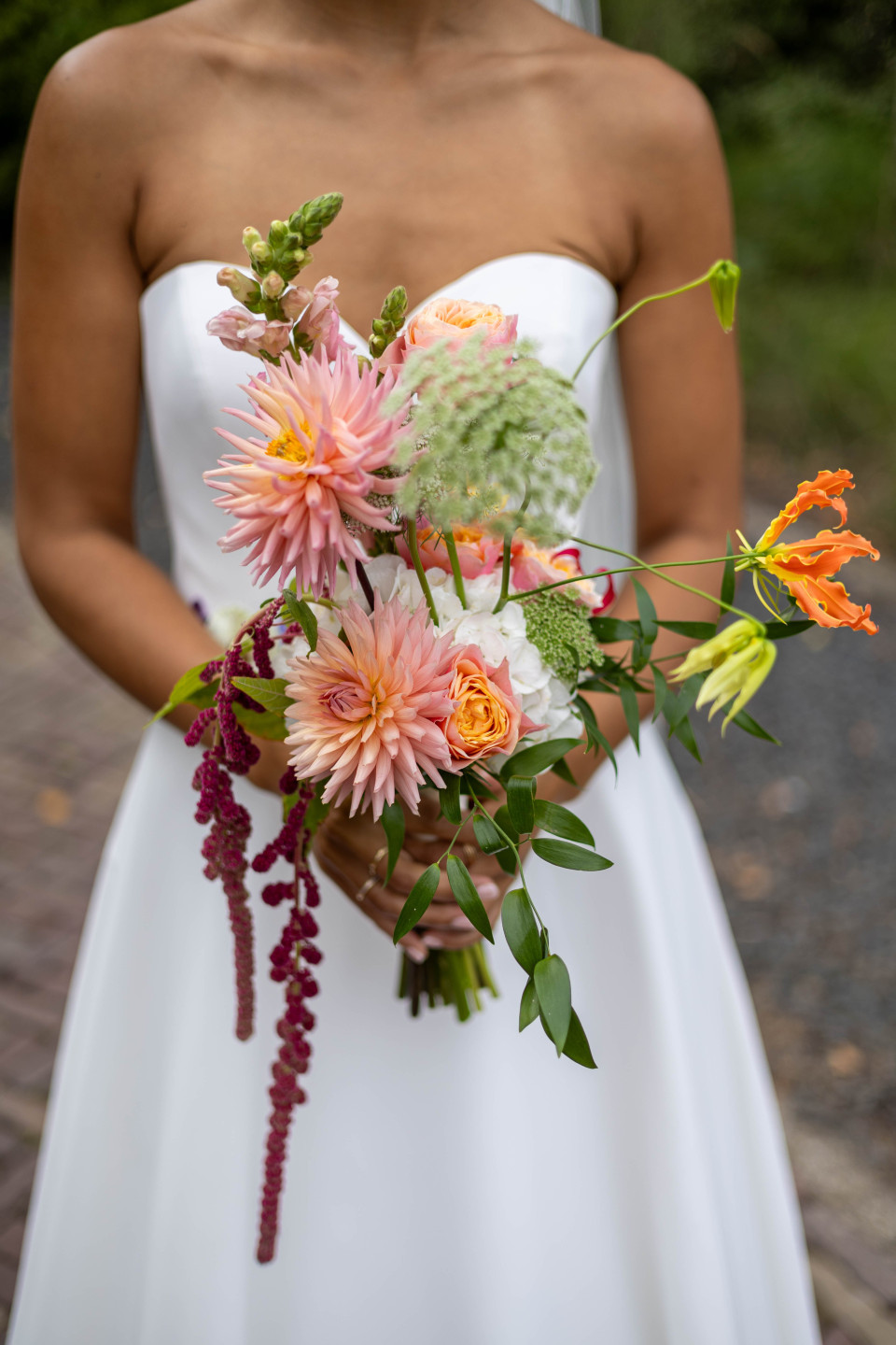 een vrouw in een trouwjurk die een boeket bloemen vasthoudt