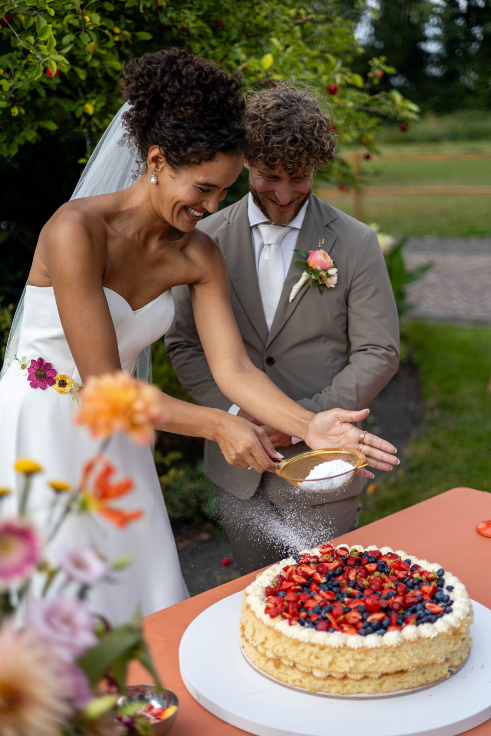 een man en een vrouw die samen een taart snijden