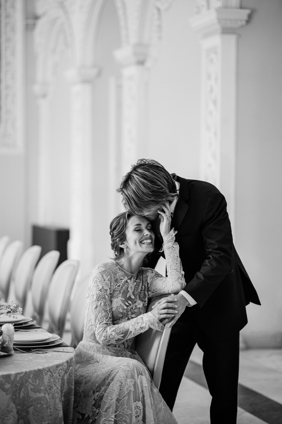 een bruid en bruidegom kussen voor een tafel