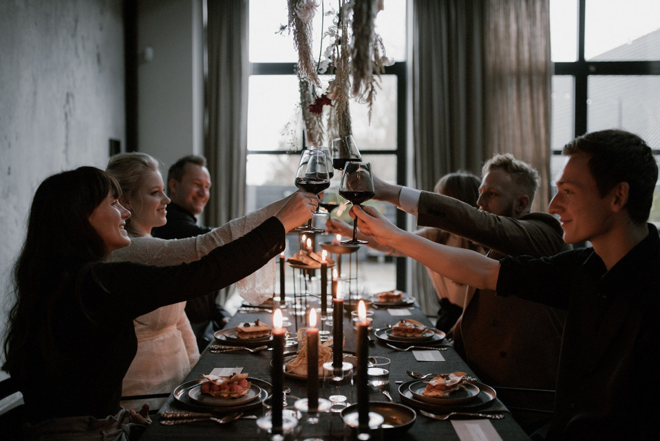 een groep mensen proosten aan een dinertafel
