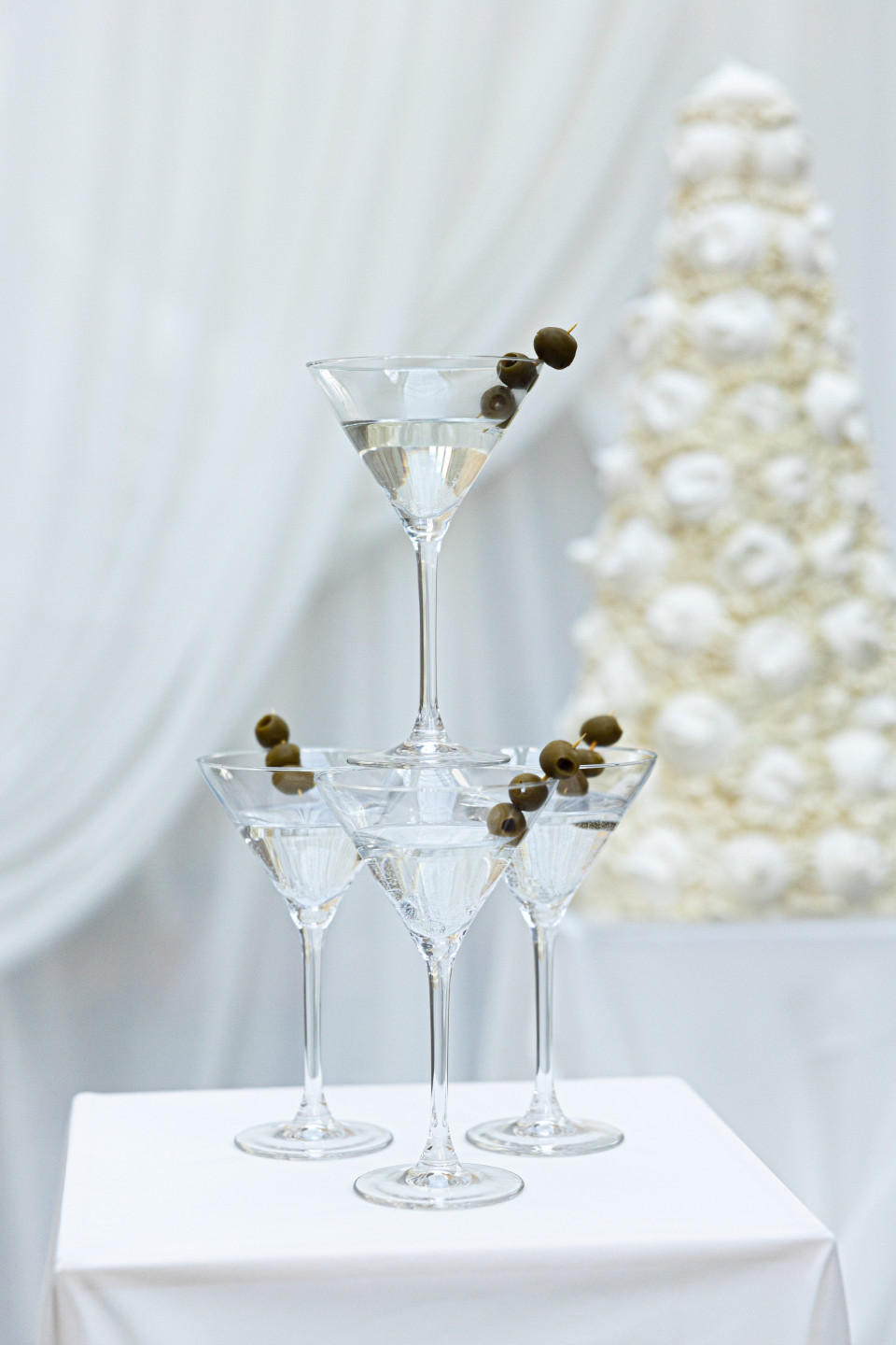 een toren van martini-glazen met olijven erin