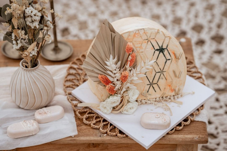 een trouwtaart met een bloemendesign staat op een houten tafel