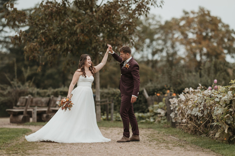 een bruid en bruidegom die hun handen in de lucht houden