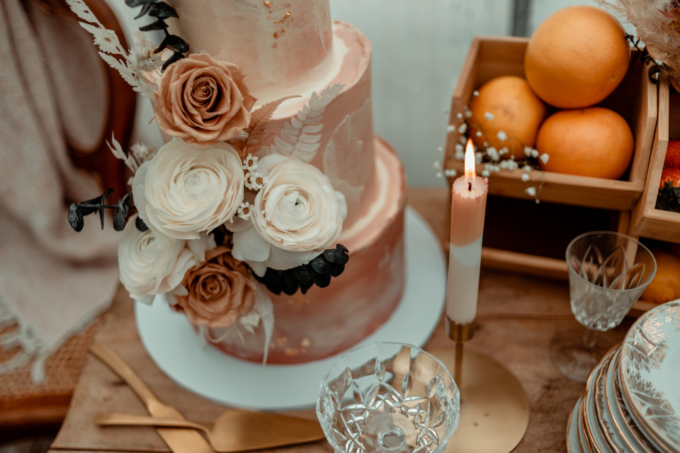 een bruidstaart met rozen en sinaasappels op een tafel