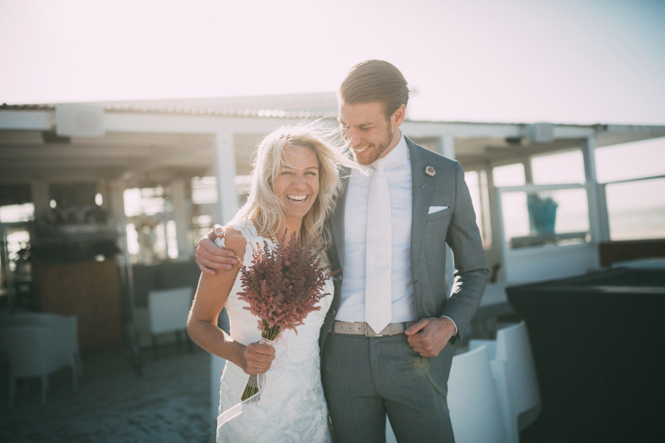 een bruid en bruidegom poseren voor een foto op een boot