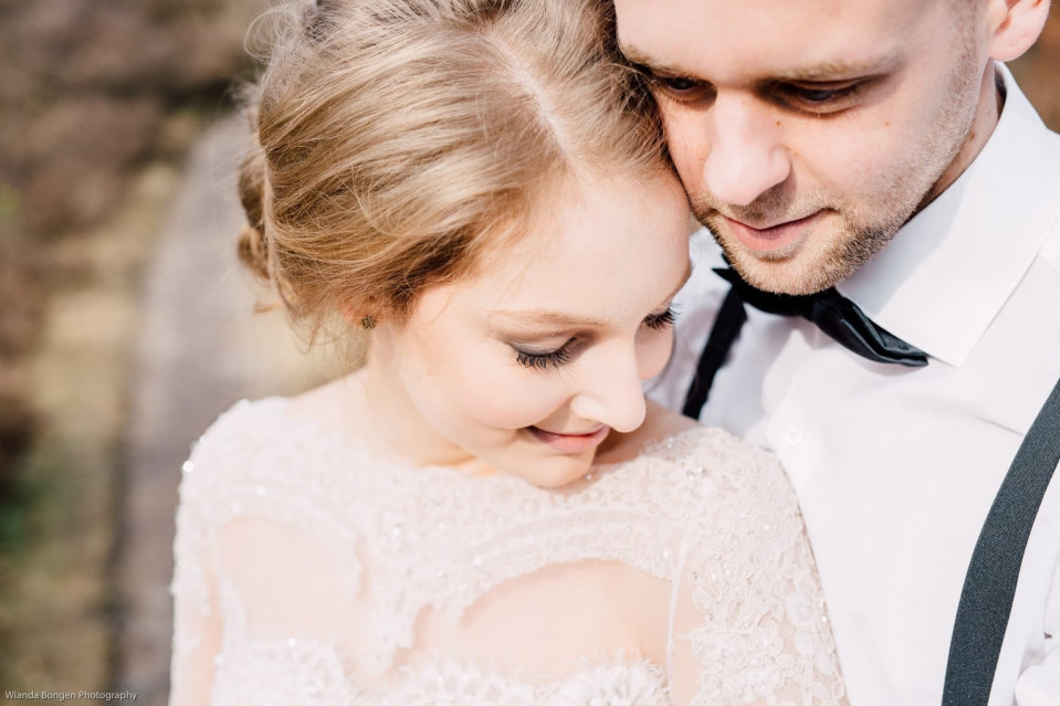 een bruid en bruidegom omhelzen elkaar in een veld