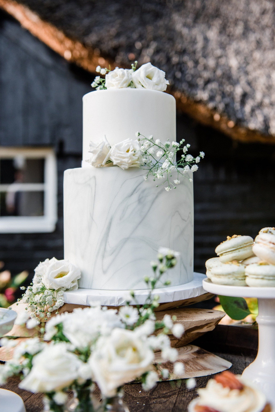 een witte bruidstaart met witte bloemen en witte rozen