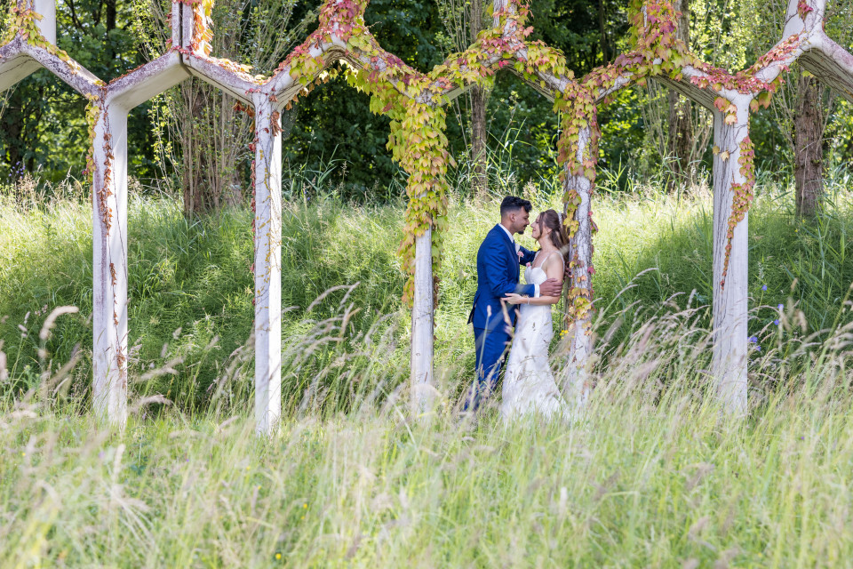 een bruid en bruidegom in een veld met hoog gras