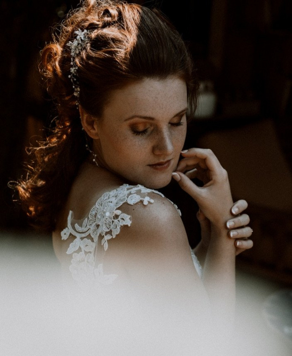 een bruid in een trouwjurk die naar haar handen kijkt