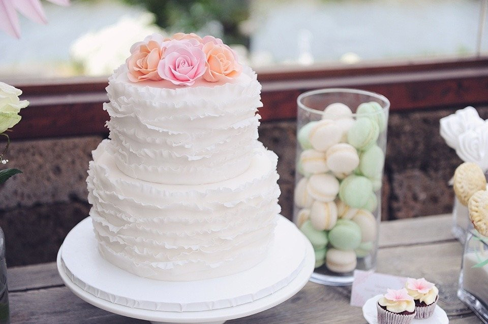 een witte taart met roze en witte bloemen erop