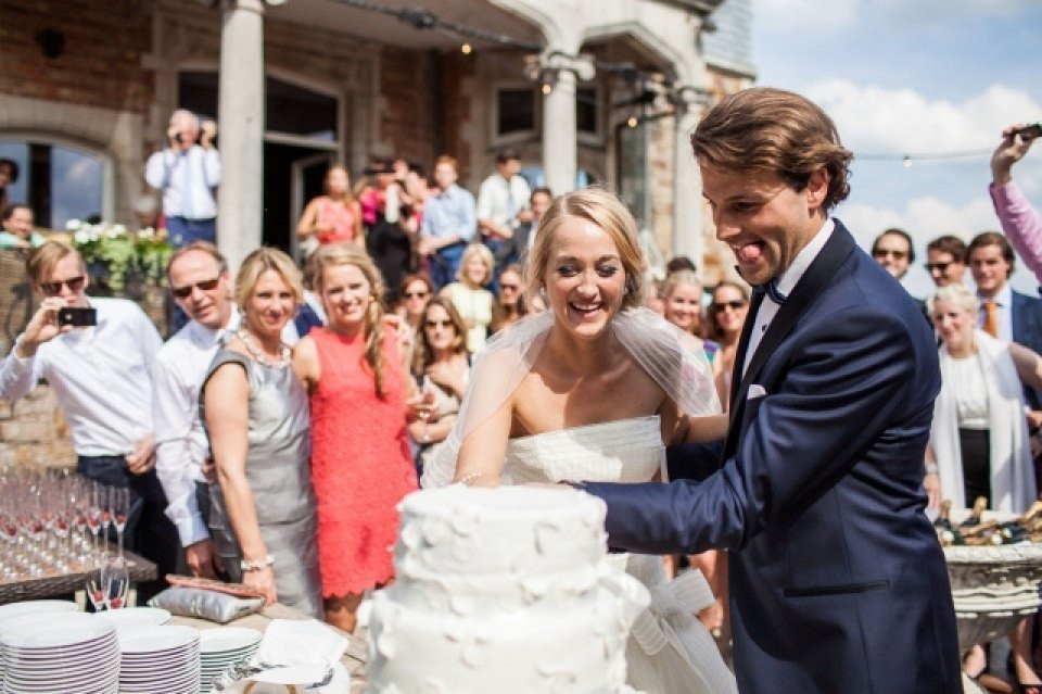 een bruid en bruidegom die hun trouwtaart aansnijden