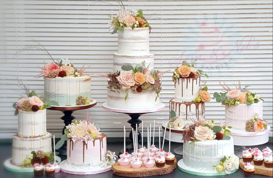 een groep taarten tentoongesteld met bloemen