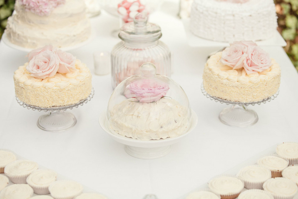 een tafel met veel taarten en cupcakes erop