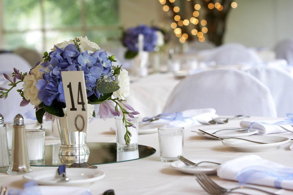 een tafel met witte en blauwe tafelkleden en tafelopstellingen