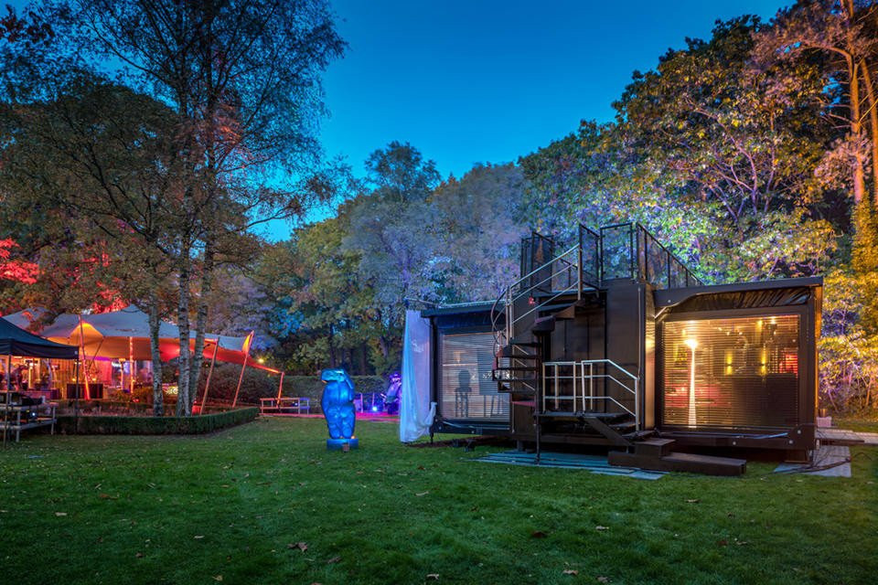 een klein huis met een trap in het midden van de tuin