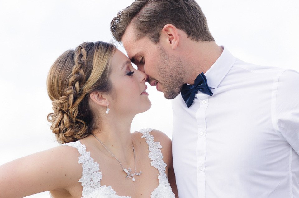 een bruid en bruidegom kussen op het strand