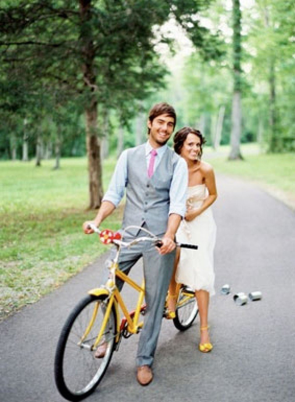 een bruid en bruidegom die op een gele fiets rijden