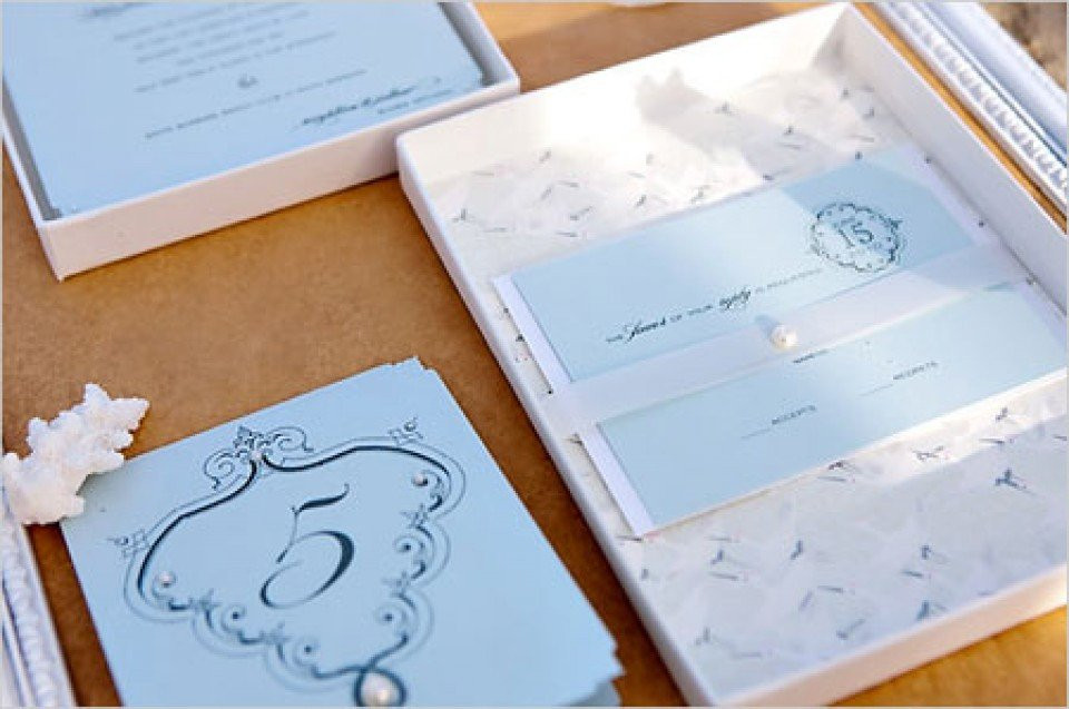 een trouwuitnodiging in een doos met een blauw lint