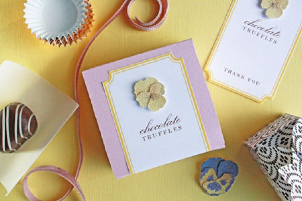 chocolade en bloemen worden getoond op een gele tafel