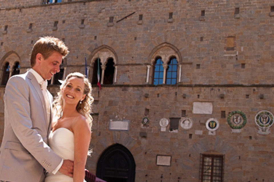 een bruid en bruidegom poseren voor een foto voor een gebouw