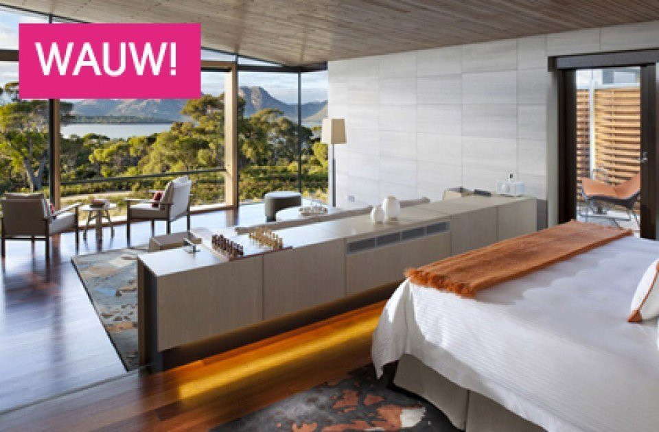 een slaapkamer met uitzicht op de oceaan en bergen