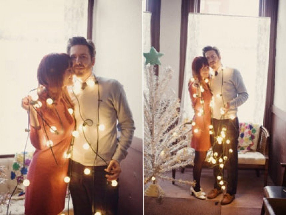 een stel poseert voor een foto met kerstverlichting
