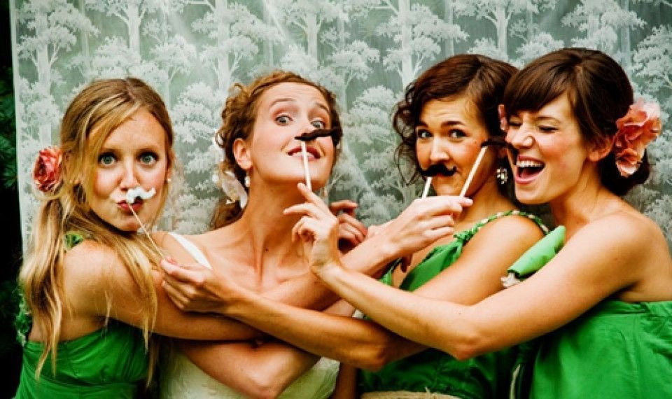 bruidsmeisjes in groene jurken poseren voor een foto