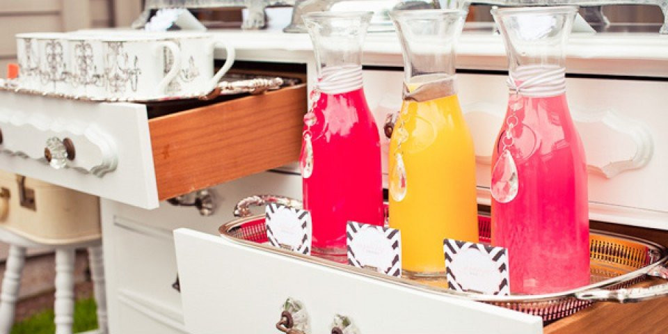 een witte commode met laden gevuld met drankjes