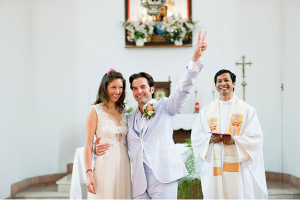 een bruid en bruidegom zwaaien naar de menigte terwijl ze het gangpad aflopen