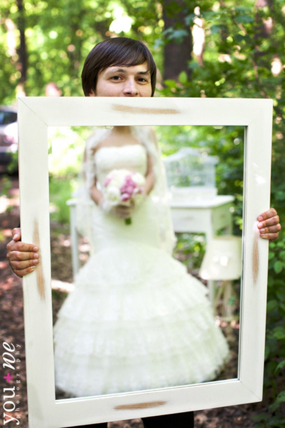 een vrouw in een trouwjurk die een spiegel omhoog houdt