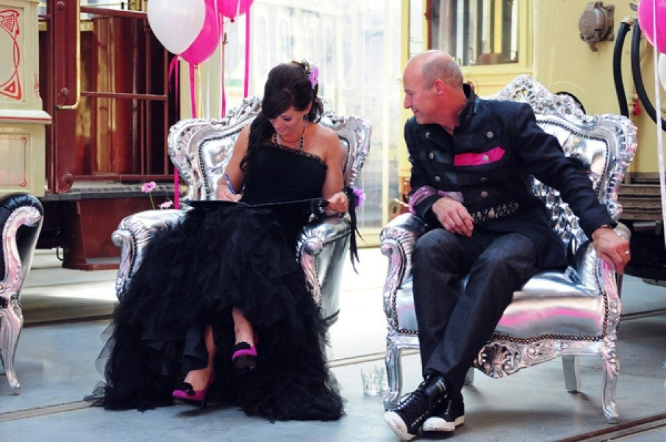 een man en vrouw in zwart en roze zittend op stoelen