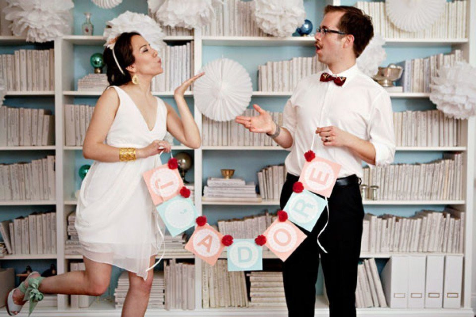 een stel poseert voor een foto voor een boekenkast