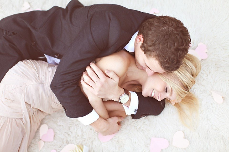 een man en vrouw in formele kledij liggen op een kleed