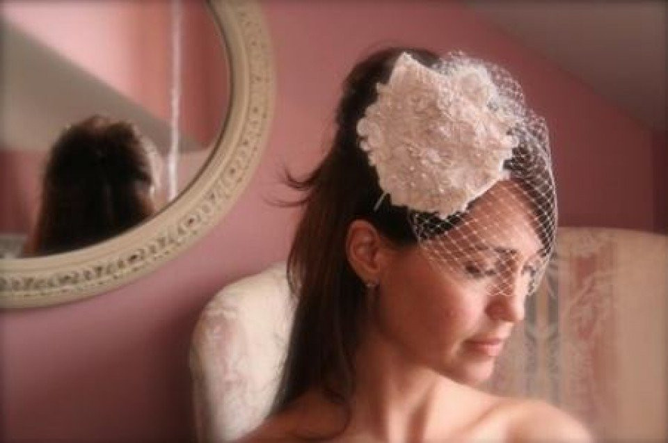 een vrouw draagt een bruidssluier en een hoed