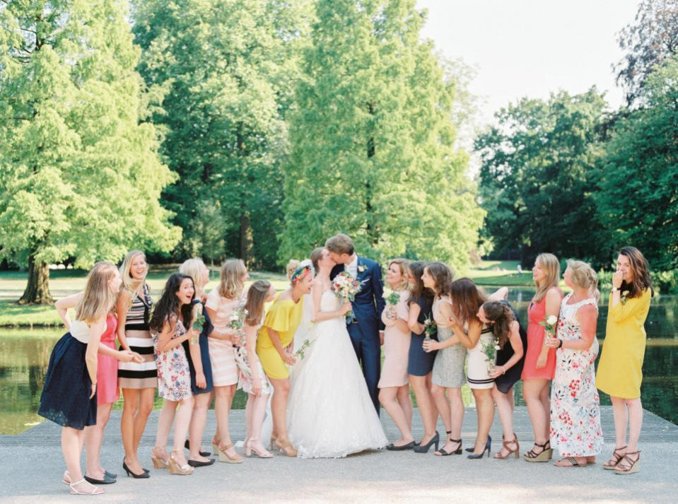 een groep bruidsmeisjes en bruidegommen poseren voor een foto