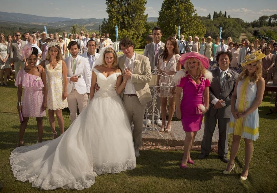 een bruiloftsfeest poseert voor een foto voor een bruidstaart