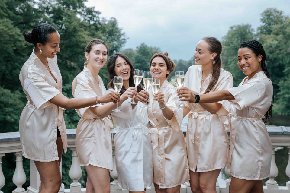bruidsmeisjes in badjassen toosten met champagne