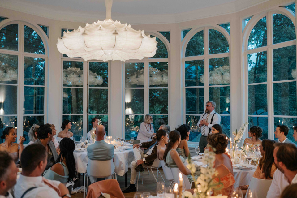 een trouwreceptie in een grote zaal met veel mensen