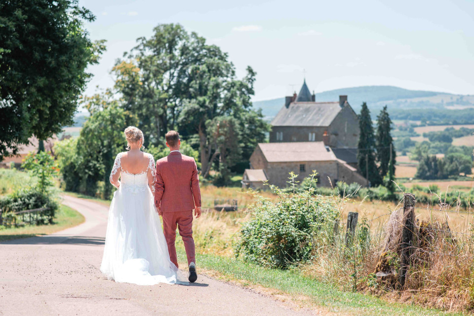 een bruid en bruidegom die een plattelandsweg aflopen