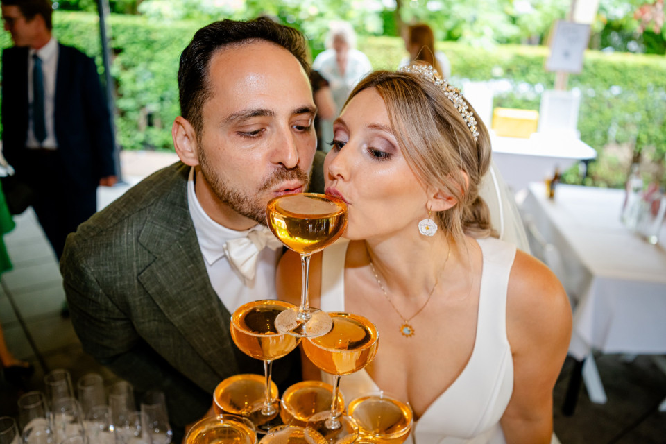 een man die een vrouw kust met een glas wijn