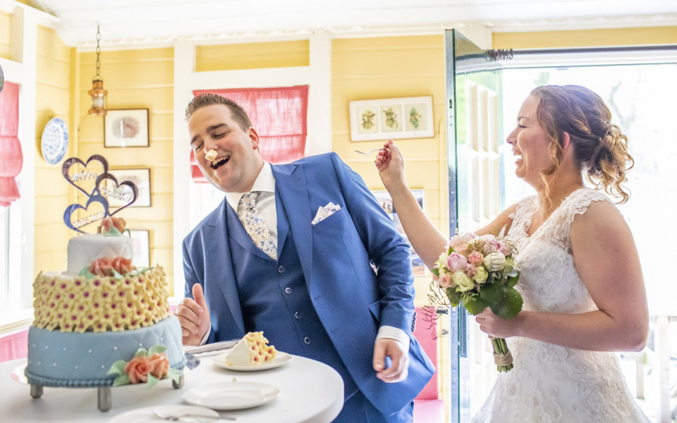 een bruid en bruidegom snijden in hun bruidstaart